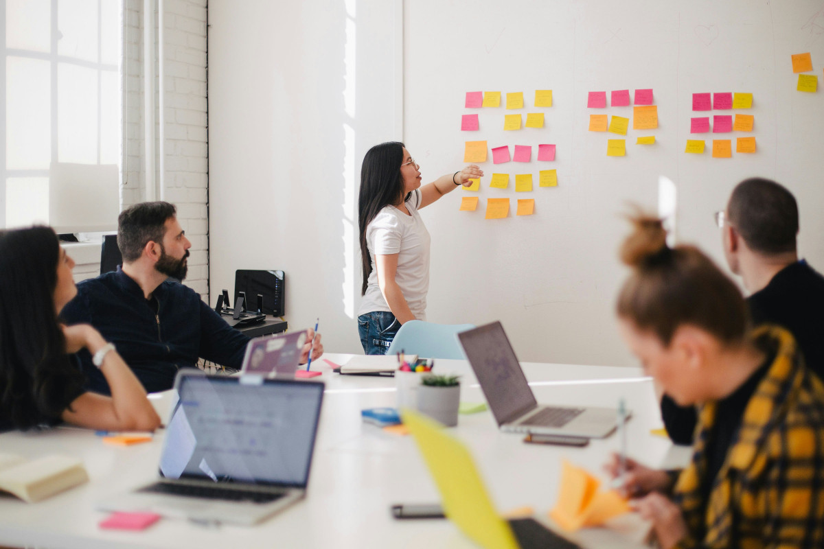 Team plant ein Projekt mit Post-Its und einem Whiteboard zur visuellen Strukturierung der Ideen.